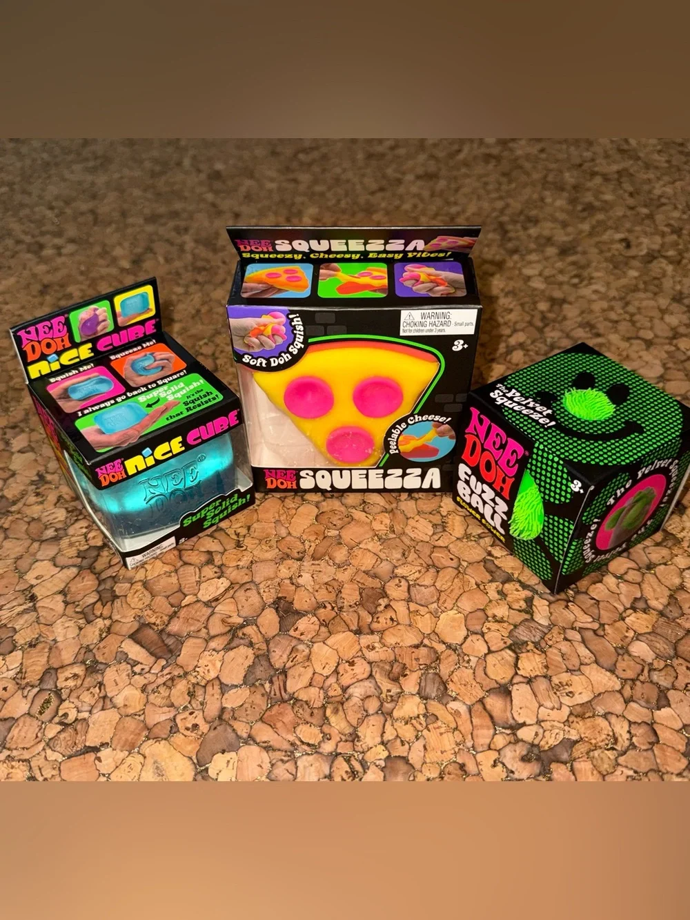 Authentic NeeDoh pizza, blue nice cube, and green flower power fuzzball